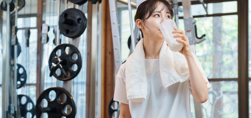ジムでプロテインの飲む女性