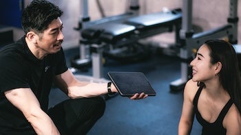 パーソナルトレーナーの説明を受ける女性