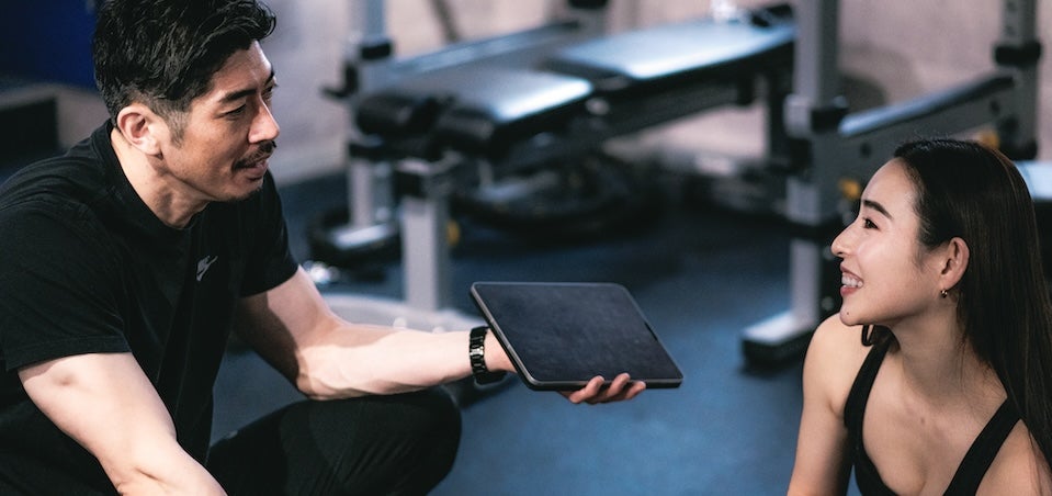 パーソナルトレーナーの説明を受ける女性