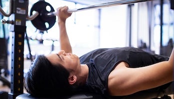 ベンチプレスでトレーニングする男性