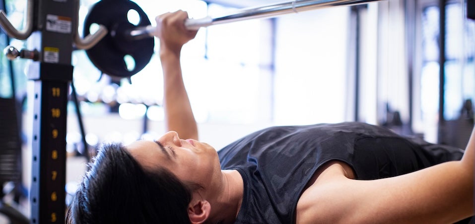 ベンチプレスでトレーニングする男性